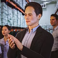 Man Applauding in Warehouse with Colleagues and Shelves Full of Boxes