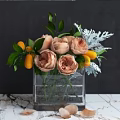 Glass Vase With Peach Roses Green Leaves Silver Foliage And Yellow Fruits On Marble Surface