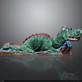 Vibrant Green Dragon Sculpture With Red Accents Lying On Brown Base Artistic