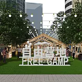 Vibrant Commercial Street with Tents String Lights and Green Grass at Free Camp
