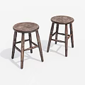 Two Round Wooden Stools With Natural Wood Grain And Carved Legs