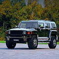 Black Hummer SUV Parked On Outdoor Road With Green Trees Background