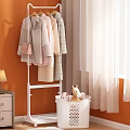 White Clothes Rack with Hanging Coats Dresses near Laundry Basket Stuffed Toys Orange Wall Curtain