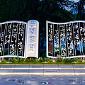 Modern Sculpture with Calligraphy on Screen like Structure Green Plants and Water Reflection