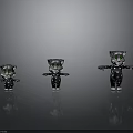 Three Different Sizes Cat Figurines In Black White Spots With Green Eyes On Gray Background