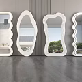 White Mirrors of Various Shapes Leaning Against Textured Wall Reflecting Outdoor Views on Gray Floor