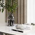 Green Foliage in Transparent Vase on White Marble Tabletop with White Teapots and Horticulture Books
