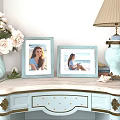 Two Decorative Light Blue Photo Frames With Seaside Photos On Dresser With Flowers And Seashells