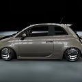 Olive Green Sporty Small Car With Custom Alloy Wheels In Motion