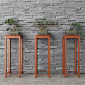 Bonsai Plants Displayed On Red Wooden Plant Stands Against Gray Brick Wall