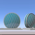 Circular Buildings With Turquoise Diamond Patterned Glass And Light Colored Base Against Blue Sky