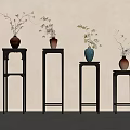 Black Flower Stands With Vases And Plants Against Light Colored Wall And Gray Floor