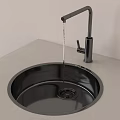 Round Black Kitchen Sink With Modern Faucet Running Water On Gray Countertop