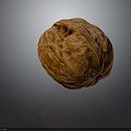 Close Up Of Single Whole Brown Walnut With Textured Surface On Gray Background