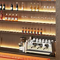 Modern Commercial Equipment with Wooden Wine Racks Various Bottles Wine Glasses and Orange Counter