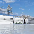 Snowy Landscape With Ice Structure Person Walking Snow Covered Trees Blue Sky And Water Reflection