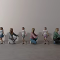 Women and Children Squatting Holding Hands in a Line Against Gray Wall and Floor
