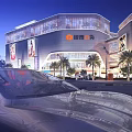 Illuminated Modern Commercial Complex With Glass Facade Palm Trees And Car In Foreground