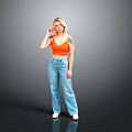 Blonde Woman In Orange Crop Top And Blue Wide Leg Jeans Standing Against Gray Background
