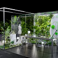 Transparent Exhibition Booth Interior With Green Plants Mannequin Table And Artificial Realm