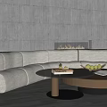 Curved Beige Sofa And Black Round Coffee Table With Fruits Book Fireplace Gray Perforated Wall