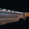 Two Black Blade Knives With Red Handles And Serrated Edges On Dark Reflective Surface
