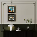 Abstract Paintings With Teal Truck And Floral Designs Hanging On Interior Wall With Table Lamp
