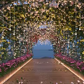 Beautiful Pergola With Hanging Lights Vines And Colorful Flowers Along Wooden Walkway