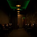 Dimly Lit Lounge Space With Chairs Candles Wall Graffiti And Green Ceiling Lights