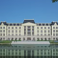 Classical Symmetrical Office Building With Water Pond Reflection And Green Lawn Exterior