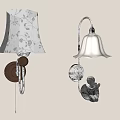 Two Decorative Wall Lamps With Floral And White Lampshades Brown Silver Bases And Angel Decoration