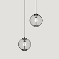 Two Glass Globe Pendant Lights Hanging Against Gray Wall With Illuminated Bulbs
