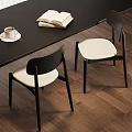 Modern Dining Chairs With Black Frame And White Padded Seats By Wooden Table