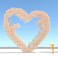 Giant Orange Heart Shaped Sculpture Constructed With Blocks And Person Standing Nearby