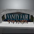 Vanity Fair Stage Setup With Group Of Performers In Orange Outfits On White Platform
