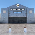 Gray Concrete Entrance Gate With Top Emblem White Square Decorative Structures And Stone Pavement