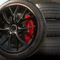 Black Alloy Wheel With Red Brake Calipers And Stacked Performance Tires