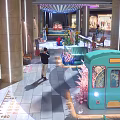Decorative Teal Tram In Indoor Mall With Columns And Pedestrians Around
