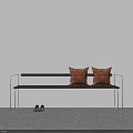 Black Bench with Two Orange Cushions and Black Shoes Against White Wall and Gray Floor