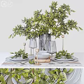 Stylish Tableware Set with Green Plants Wine Glasses Plates and Candle Holders on White Table