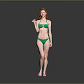 Woman with red hair wearing green bikini standing against gray background barefoot in natural pose
