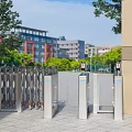 Entrance Gate With Automatic Turnstiles Flanking Pillars Surrounding Trees And Background Buildings Under Blue Sky