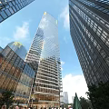 Modern High Rise Office Building With Glass Facade And Urban Skyline Under Clear Blue Sky