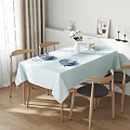 Bright Sunlit Minimalist Dining Room With Natural Wood Chairs And Soft Light Blue Tablecloth