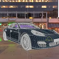 Blue Sports Car Parked On City Street With Tall Buildings And Evening Lights