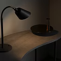 Black Desk Lamp With Golden Curved Arm Modern Design On Gray Curved Tabletop