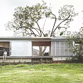 Modern Detached Villa With Large Glass Windows Lawn And Surrounding Trees