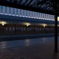 Well Lit Railway Station Platform Featuring Glass Canopy Tracks And Lamps
