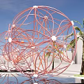 Illuminated Spherical Wireframe Sculptures With Palm Trees In Outdoor Twilight Sky