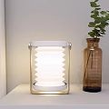 Modern Table Lamp With Spiral Shade Wooden Handle Metal Base On White Shelf Green Plant